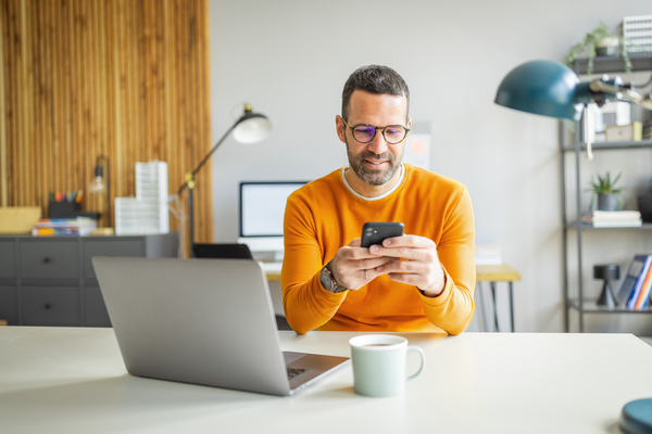 man on phone by computer
